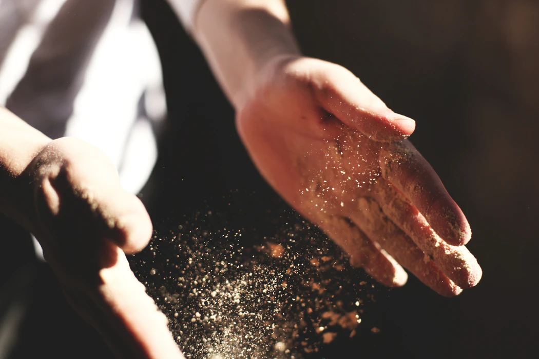 Person clapping their hands with dust